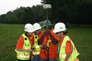 Suzanne Kloth, Karen Arp, and Cheryl Panchyn learn from Ronald Watson how to operate our EGPS survey equipment while staking out a flag position