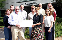 Trent Turk, CEO, presents check to Carol Widsom of Must Ministries..
